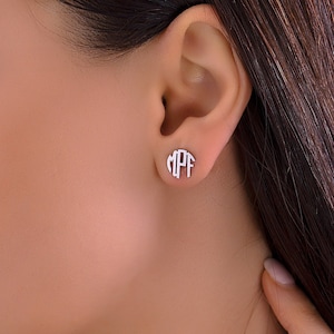 May include: Silver monogram earrings with the letters "M P F" in a circle.