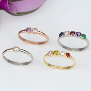 Peut inclure: Quatre bagues différentes avec des pierres précieuses colorées. Les bagues sont en argent, or et or rose. Les pierres précieuses sont roses, jaunes, bleues, rouges et vertes.