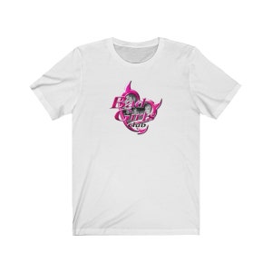 May include: White t-shirt with a pink and silver graphic that reads "Bad Girls Club." The design features a bold, cursive font. The shirt is made of a soft, comfortable material. A casual, everyday garment.