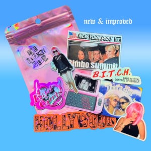 Pu&ograve; includere: Una collezione di adesivi e una borsa olografica su sfondo blu. Gli adesivi includono testo come "The Hockey Club", "Bad Girls Club", "Hollywood" e "B.I.T.C.H.". Altri adesivi presentano immagini di donne e un telefono rosa.