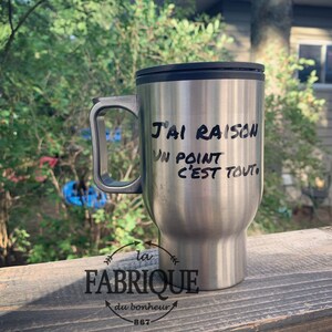 Peut inclure: Une tasse à café isotherme en argent avec un couvercle et une poignée noirs. La tasse porte l'inscription noire "J'ai raison un point c'est tout."  Le fond de la tasse porte un logo noir qui dit "la fabrique du bonheur 867".