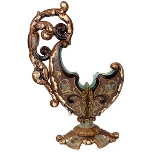 Puede incluir: Un jarrón de cerámica grande y ornamentado con un acabado marrón y dorado. El jarrón tiene una forma única y curvada y diseños florales intrincados.