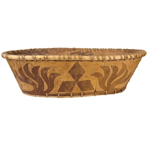 Peut inclure: Panier ovale en écorce de bouleau avec un motif décoratif brun foncé. Le panier présente un motif géométrique avec un losange central et des formes stylisées en forme de feuilles. Le bord est renforcé avec du matériau tissé.