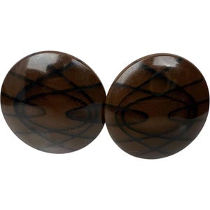 May include: A pair of brown and black patterned earrings. The earrings are round and have a geometric design.