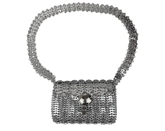 May include: A silver chainmail crossbody bag with a silver clasp. The bag is made of small, interlocking metal rings.