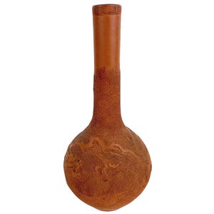 May include: A brown gourd-shaped vase with a long neck and a round base. The vase features a textured surface and a carved dragon design on the base. The neck has a geometric pattern near the top.