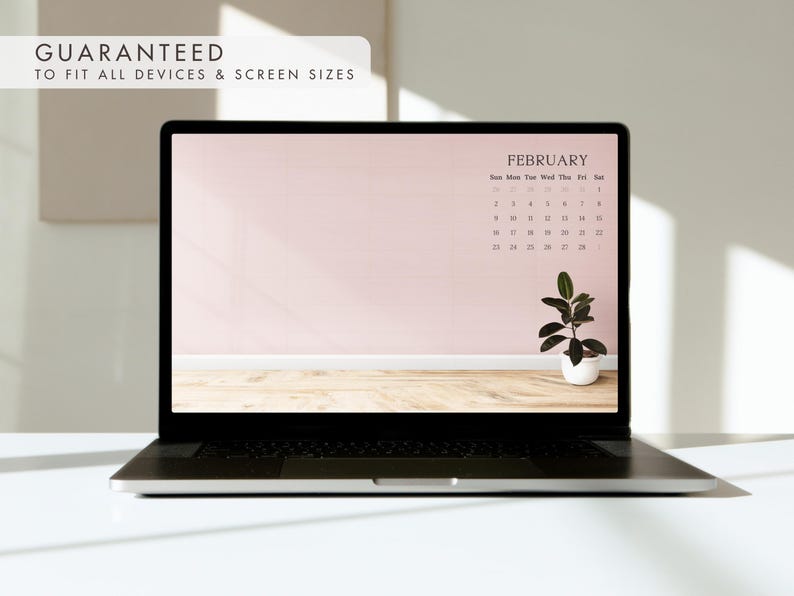 May include: A laptop displays a February calendar on a pink background with a small potted plant. The text "GUARANTEED TO FIT ALL DEVICES & SCREEN SIZES" is in the upper left corner. The laptop is on a white surface.