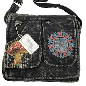 May include: A black acid-wash messenger bag with an adjustable shoulder strap and two front pockets. The left pocket features a mushroom graphic, while the right pocket displays a circular, multi-colored embroidered mandala design.