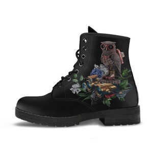 May include: Black combat boot featuring a steampunk owl design. The owl is wearing goggles and a backpack, surrounded by flowers, gears, and binoculars. The boot has a lace-up closure and a sturdy sole.