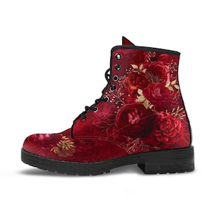 Puede incluir: Botas de cuero rojas con estampado floral de rosas rojas y detalles dorados. Las botas tienen cierre de cordones y un tacón grueso.