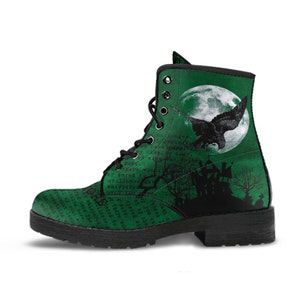 May include: Green combat boots with a black raven graphic in front of a full moon. The boots feature a spooky haunted house and tree design, with text overlay. Black laces and a black sole complete the look.
