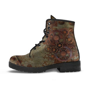 May include: A distressed leather boot with a steampunk design. The boot features a rusty, gear-themed graphic on a weathered, olive-green background. Black laces and a black sole complete the look. The boot is a unique fashion statement.