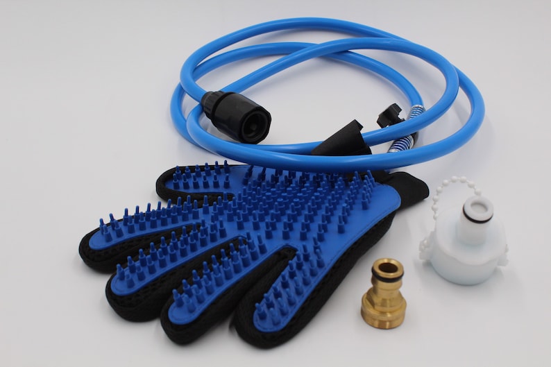 May include: A blue pet grooming glove with silicone bristles, a blue hose, a white bottle, and a brass fitting. The glove is black on the back and has a loop for hanging. The hose is coiled.
