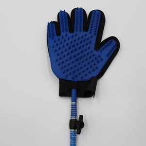 May include: Blue pet grooming glove with rubber bristles. The glove is attached to a blue hose with a black valve. The glove is black around the wrist area.