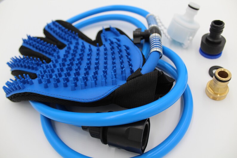 May include: A blue pet grooming glove with silicone bristles, a blue hose, and various connector pieces. The glove has a black mesh backing. Additional components include a white filter and black and brass connectors.