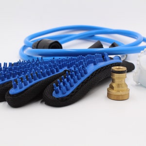 May include: A pet grooming kit featuring blue and black grooming mitts with blue bristles, a blue hose, a white plastic attachment, and a brass fitting. The kit is designed for pet bathing and grooming.