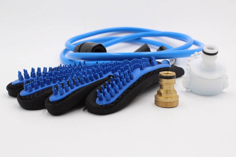 May include: A pet grooming kit featuring blue and black grooming mitts with blue bristles, a blue hose, a white plastic attachment, and a brass fitting. The kit is designed for pet bathing and grooming.