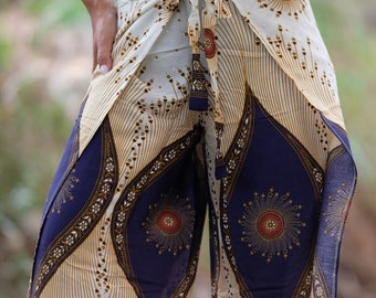 May include: White wrap trousers with a blue and gold geometric pattern. The trousers have a tie at the waist and are made of a lightweight fabric.