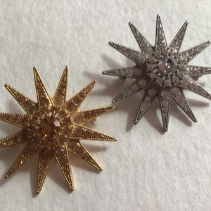 Graziano two vintage Starburst sparkly brooches one gold one silver.