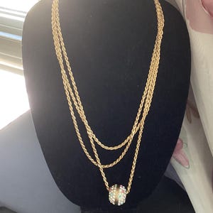 Collier vintage avec pendentif boule en corde. Ton doré. Strass multicolore
