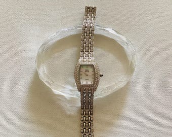 Vintage Nolan Miller Glamour Collection silver-tone rhinestone quartz watch with a mother-of-pearl dial.