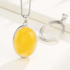 Peut inclure: Un collier argenté avec un pendentif ovale jaune suspendu à une chaîne carrée, accompagné d'une monture de pendentif ovale vide. Le texte ClareAccessories est visible dans la partie supérieure de l'image.