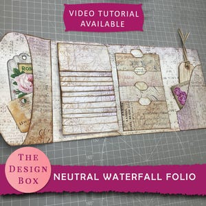 Puede incluir: Un folio cascada neutro de estilo vintage, abierto para mostrar su contenido. Presenta múltiples bolsillos, etiquetas y páginas superpuestas con texto impreso y acentos florales. El diseño incluye el texto "VIDEO TUTORIAL AVAILABLE" y "THE DESIGN BOX NEUTRAL WATERFALL FOLIO".