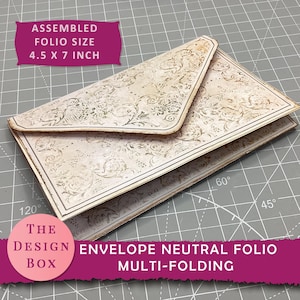 Puede incluir: Un sobre folio neutro con un diseño de plegado múltiple. El tamaño ensamblado es de 11,4 x 17,8 cm. El sobre tiene un fondo color crema con un patrón floral y un borde oscuro. El texto "THE DESIGN BOX" y "ENVELOPE NEUTRAL FOLIO MULTI-FOLDING" son visibles.