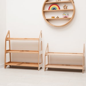 May include: Two wooden shelves with three shelves each. The shelves are made of light wood and have a simple design. The shelves are standing on a white floor.