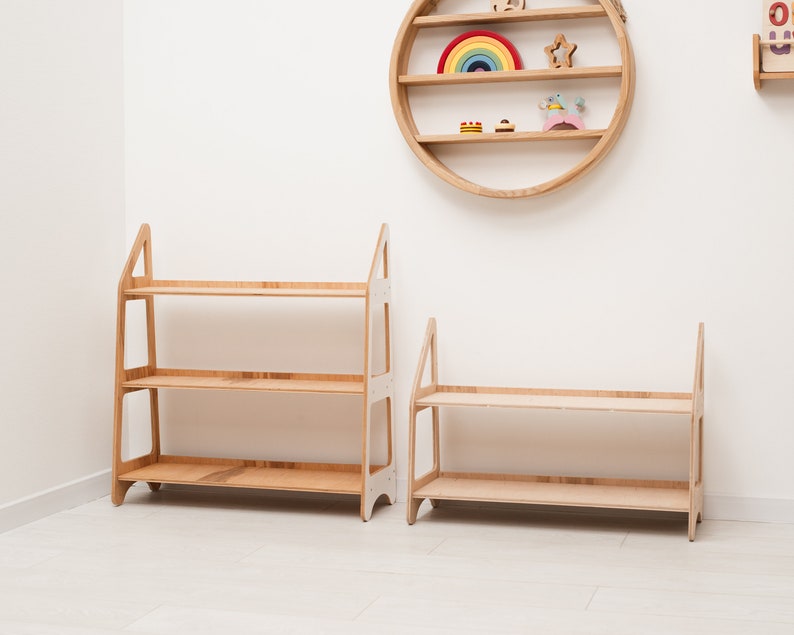 May include: Two wooden shelves with three shelves each. The shelves are made of light wood and have a simple design. The shelves are standing on a white floor.