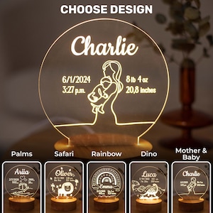 May include: A personalised night light with the name "Charlie" and birth details: date, time, weight (3.6 kg), and length (52.8 cm). The design features a mother holding a baby. Additional design options are shown below.