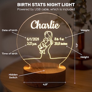 May include: A personalised birth stats night light featuring the name "Charlie". The light shows the date and time of birth, weight (3.7 kg) and height (52.8 cm). It has a wooden base and is 12.2 cm wide and 20.1 cm tall. Powered by USB.