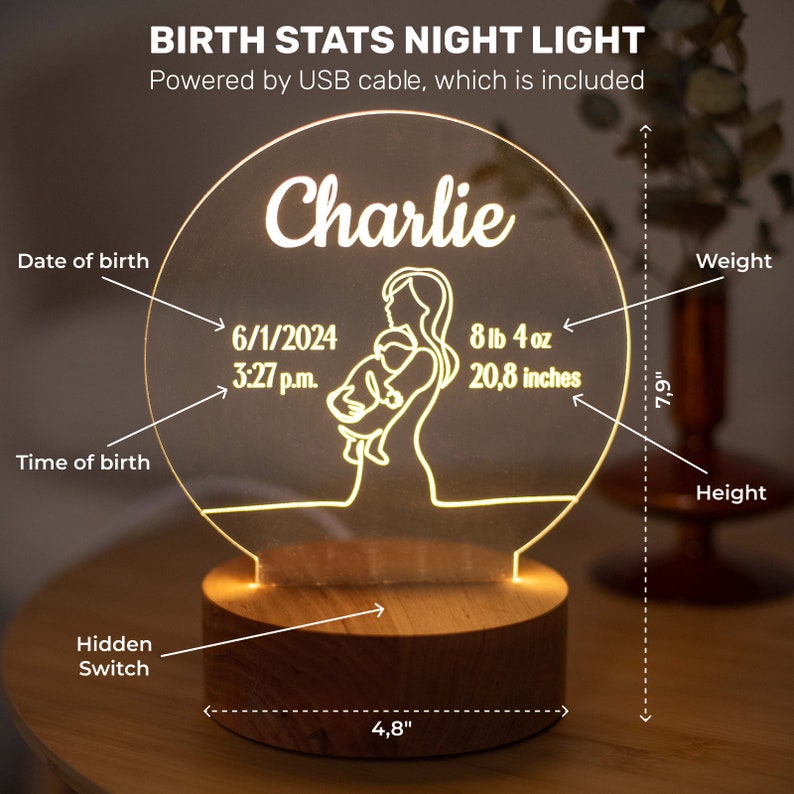 May include: A personalised birth stats night light featuring the name "Charlie". The light shows the date and time of birth, weight (3.7 kg) and height (52.8 cm). It has a wooden base and is 12.2 cm wide and 20.1 cm tall. Powered by USB.