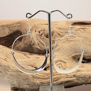 Round dangling earrings, hoop style, in sterling silver.