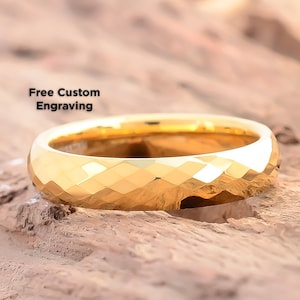 May include: A gold tungsten carbide ring with a faceted, diamond-cut design. Free custom engraving is offered.