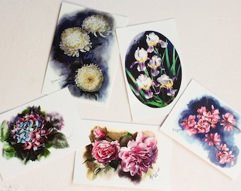 May include: Five watercolor paintings of different flowers on white card stock. The paintings feature white chrysanthemums, purple irises, pink and blue hydrangeas, pink roses, and pink cherry blossoms.
