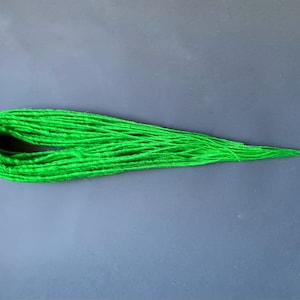 May include: A bundle of bright green synthetic dreadlocks.