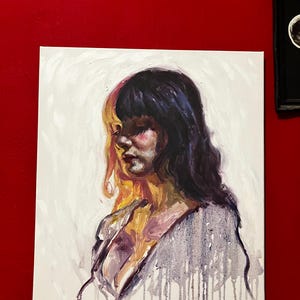May include: An oil painting on canvas shows a woman in profile with long, dark hair. The artwork has a colour split, with one side in warm yellow and the other in cool purple. The woman's face is painted with soft, blended colours.