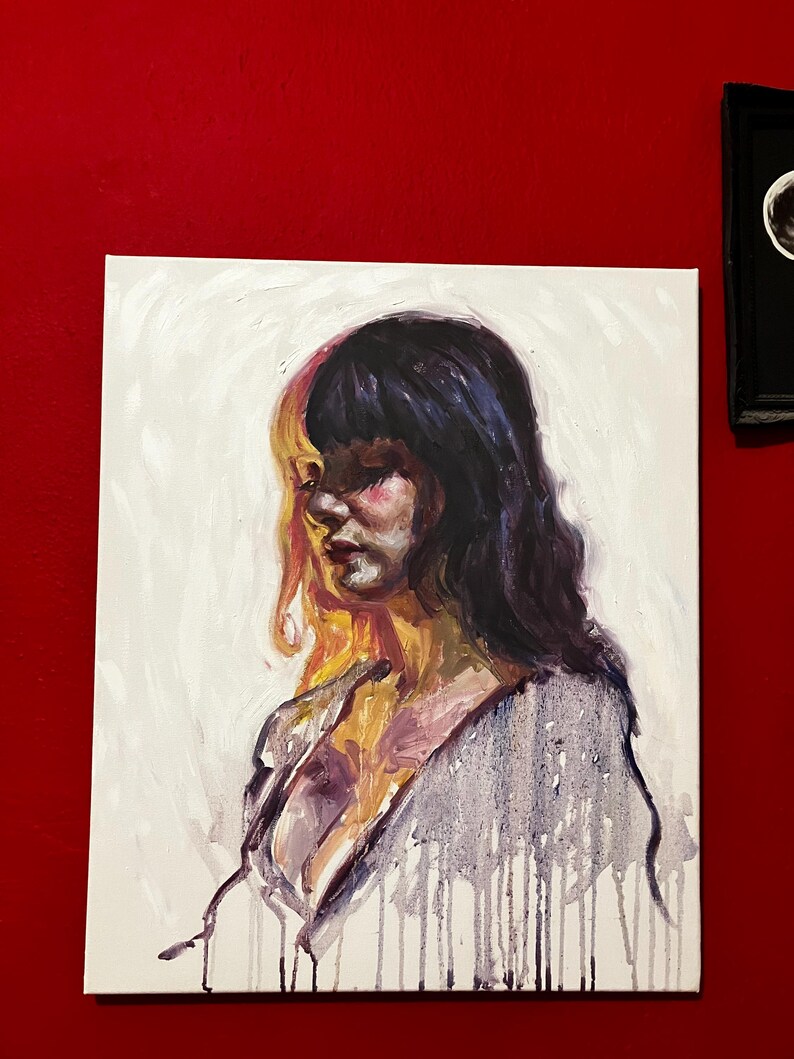 May include: An oil painting on canvas shows a woman in profile with long, dark hair. The artwork has a colour split, with one side in warm yellow and the other in cool purple. The woman's face is painted with soft, blended colours.