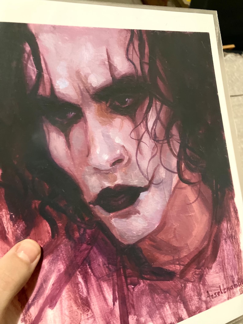 May include: A close-up painting of a man's face with dark hair and a dark, dramatic makeup look. The painting is done in a painterly style with visible brushstrokes. The artist's signature, "Anselena", is visible in the bottom right corner.