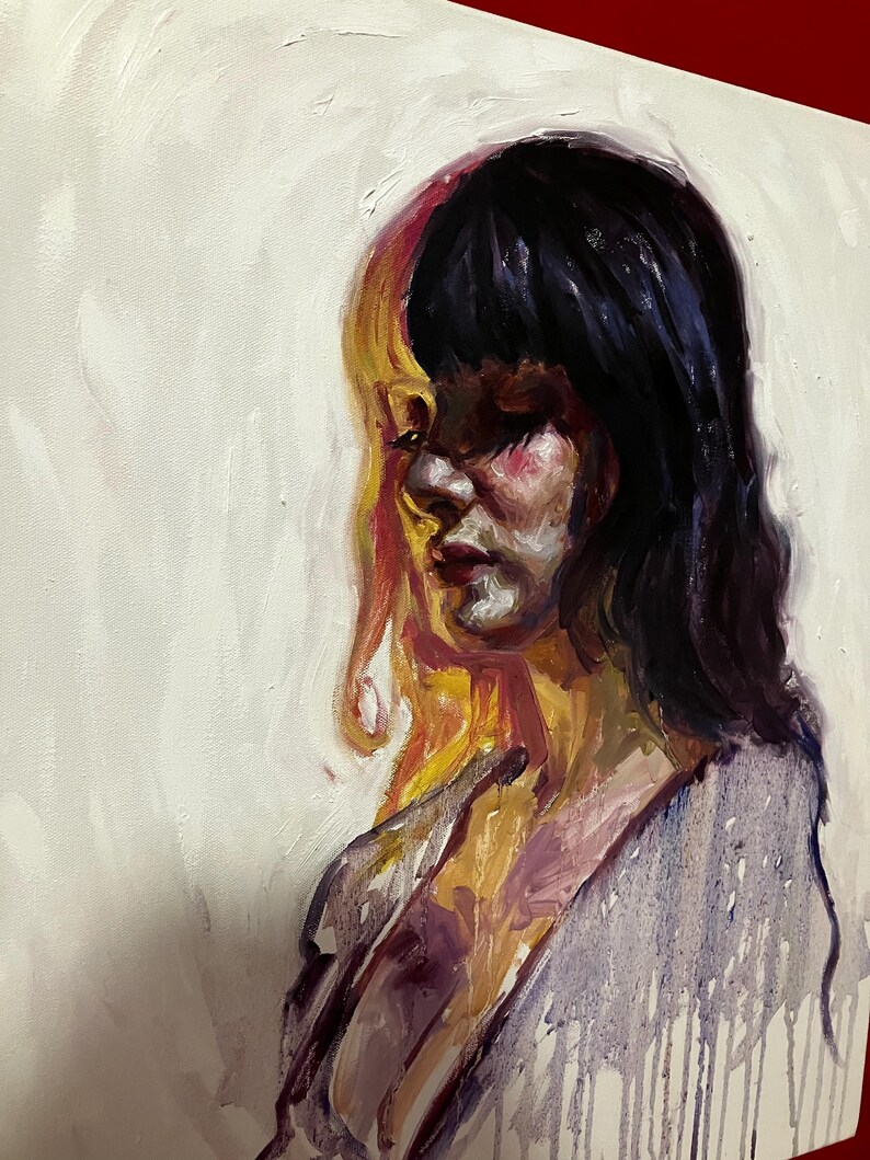 May include: Oil painting of a person with dark hair and a split face, one side yellow and the other dark. The person is looking down, with a purple and white draped garment.