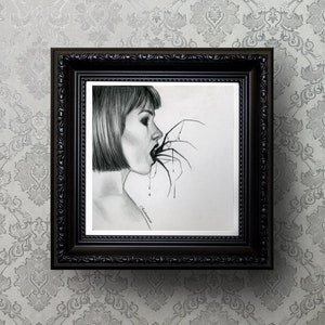 May include: A framed pencil drawing depicts a woman with short hair, her mouth open, with a spider's legs extending into it. The artwork is in a black ornate frame, hanging against a patterned gray background.