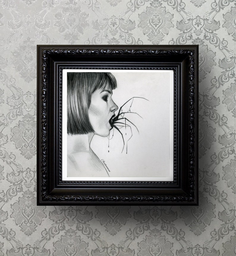 May include: A framed pencil drawing depicts a woman with short hair, her mouth open, with a spider's legs extending into it. The artwork is in a black ornate frame, hanging against a patterned gray background.