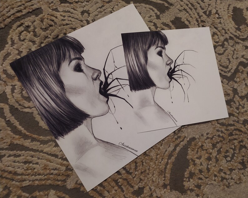 May include: Two black and white pencil drawings of a woman with short hair, her mouth open with a spider crawling out. The drawings are on white paper, with the artist's signature in the bottom right corner. The drawings are placed on a patterned surface.