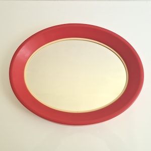 Vintage oval Memphis Milano style wall mirror in a plastic frame