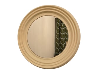May include: A round, cream-colored mirror with a thick, textured frame. The mirror has a simple, modern design.
