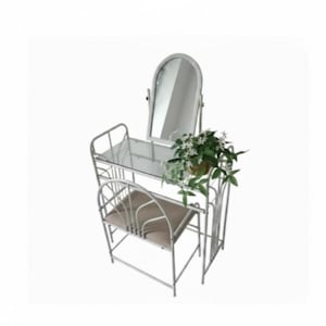 Può includere: Un set da toeletta in metallo bianco con un piano d'appoggio rettangolare in vetro e uno specchio ad arco. Il set include una sedia abbinata con seduta imbottita color beige. Una piccola pianta con foglie verdi e fiori bianchi poggia sul vetro.