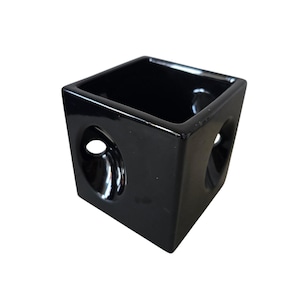 May include: A black ceramic planter with two round cutouts on the sides. The planter is square shaped and has a smooth, glossy finish.