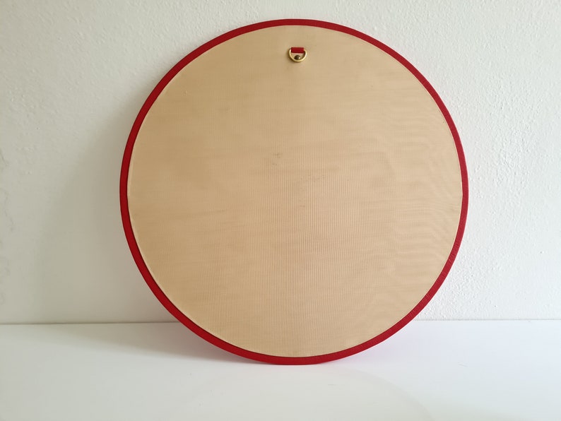 May include: A round, wooden canvas with a red border and a gold hanging loop. The canvas is blank and ready for painting.