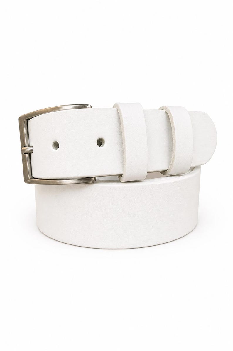 May include: A white leather belt with a silver-colored buckle. The belt has two belt loops and two holes for the buckle. The belt is a solid white color and is made of leather.